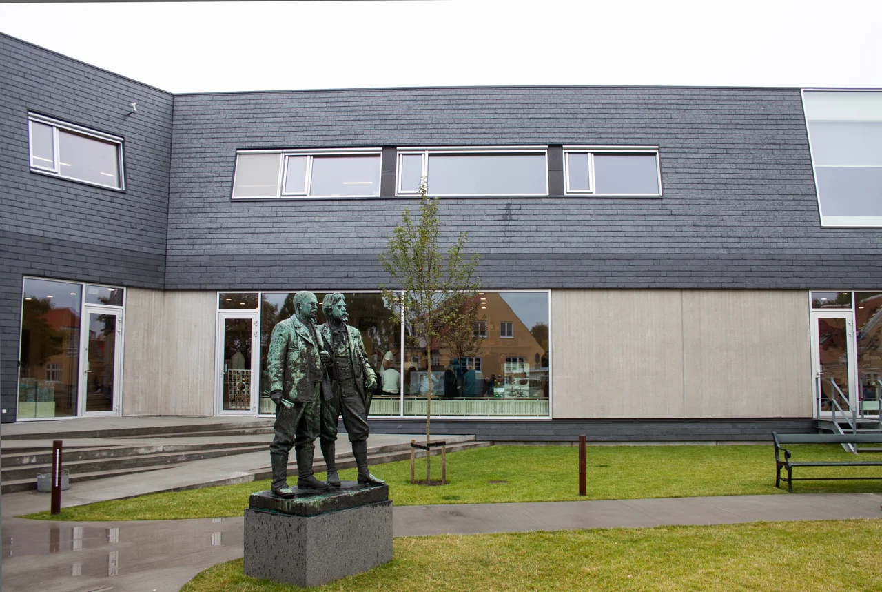 Statue of Michael Ancher and PS Krøyer by Laurits Tuxen in front of Skagens Museumlabel QS:Len,"Statue of Michael Ancher and PS Krøyer by Laurits Tuxen in front of Skagens Museum"label QS:Lhu,"Michael Ancher és PS Krøyer szobra, Laurits Tuxen alkotása, a Skageni Múzeum előtt"